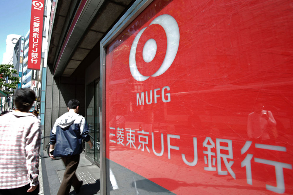 People enter a branch of Bank of Tokyo Mitsubishi UFJ Ltd. in Tokyo, Japan, on Wednesday, May 15, 2013. Japan's three biggest banks led by Sumitomo Mitsui Financial Group Inc. forecast earnings will decline this year as monetary easing makes loans less profitable even as borrowing picks up amid an economic recovery. Photographer: Kiyoshi Ota/Bloomberg